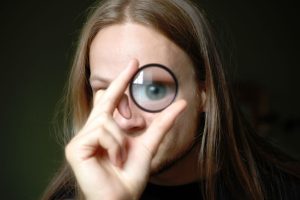 Fergus peers at the viewer through a macro lens acting as a magnifying glass.