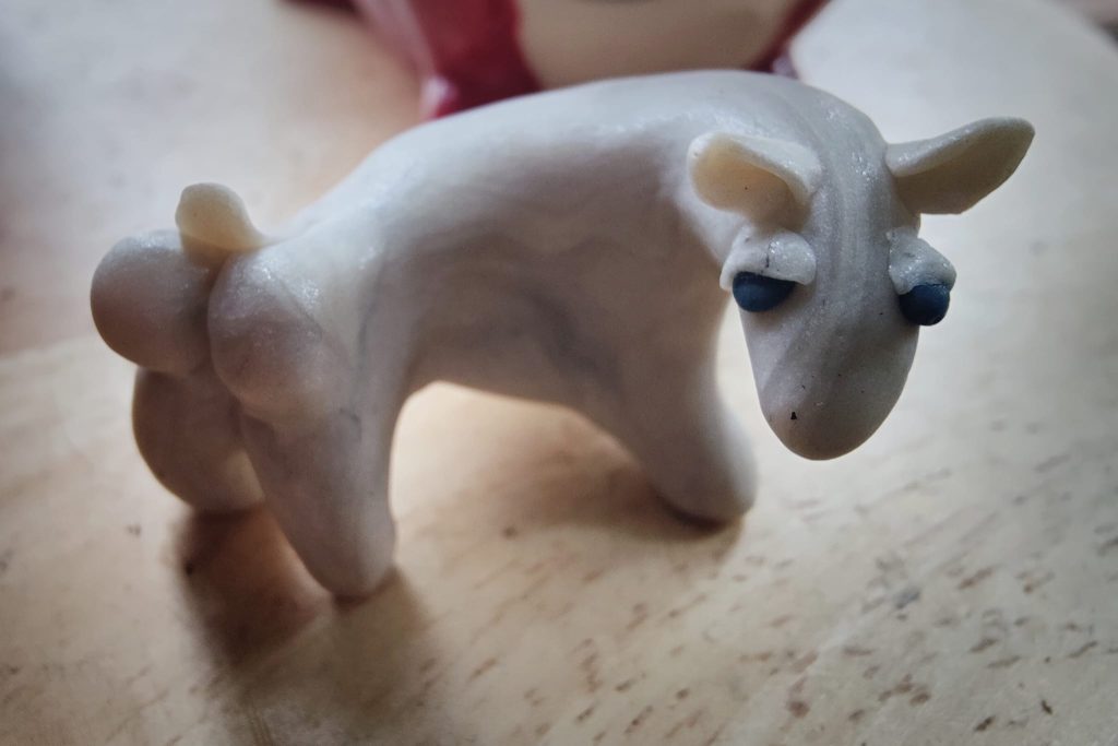 A polymer clay sculpture, bearing a passing resemblance to a Kyrgyz sheep, sees you looking at its rear.